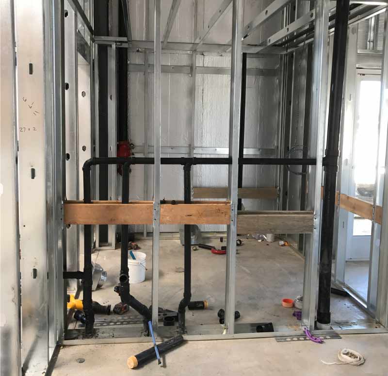 Bathroom plumbing fixtures being professionally installed during a remodeling project in Clovis, California