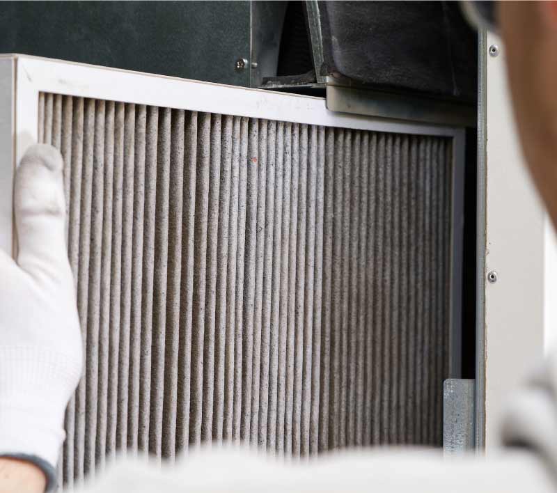 Dirty air filter being removed during a commercial HVAC maintenance service in the Central Valley